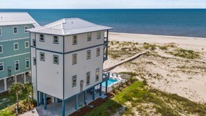 Een meerhoog gebouw met zwembad en uitzicht op het strand.