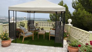 Un espace extérieur aménagé, abrité et offrant une vue sur la ville.