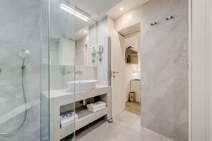 Habitación Deluxe con 1 cama matrimonial o 2 individuales | Baño | Regadera, regadera tipo lluvia, amenidades de baño gratuitas 
