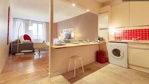A modern apartment with a kitchen, a dining area, and a living room.