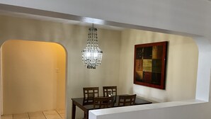 Un coin repas agrémenté d’un lustre, d’une table et de chaises.