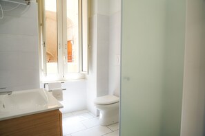 A modern bathroom with a large sink, toilet, and shower. - Vulcania Rooms (Naples)