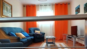 A living room with a sofa, armchair, and a small table.