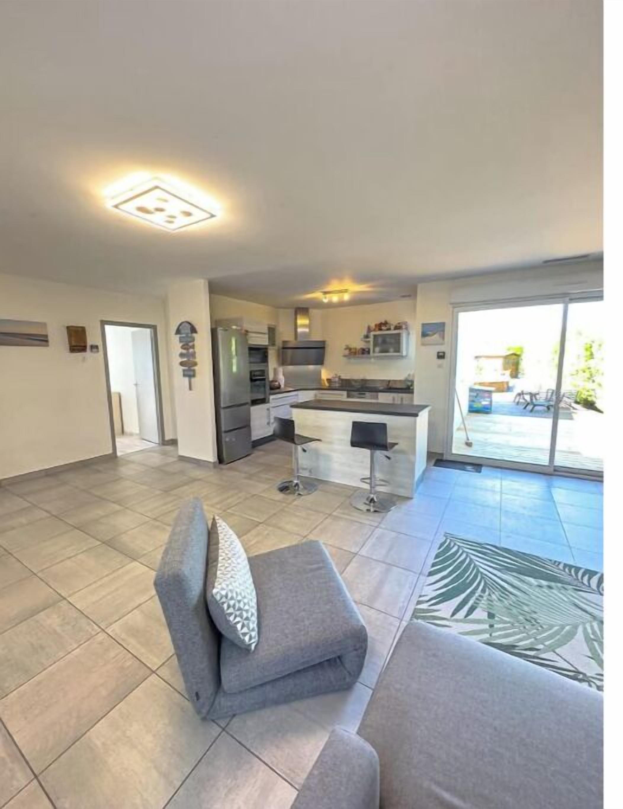 Un appartement moderne comprenant une cuisine, un coin repas et un salon avec un canapé et une table basse.