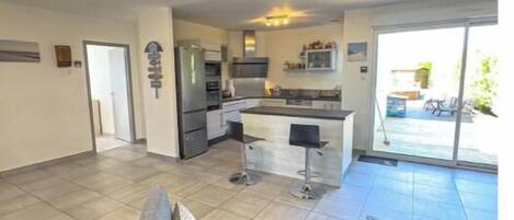 Un appartement moderne comprenant une cuisine, un coin repas et un salon avec un canapé et une table basse.