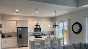 A modern kitchen with white cabinetry, stainless steel appliances, and pendant lighting. - New beautiful Pool .  May thru Dec 2025 $2599 a month.  $87a night. Contact Pam  (Rotonda West)