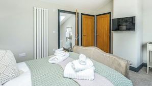Une chambre d’hôtel équipée d’un lit, d’une télévision, d’un miroir et d’une armoire.