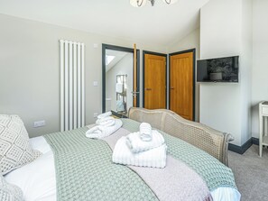 A hotel room with a bed, a television, a mirror, and a wardrobe. - 3 bedroom accommodation in Bellshill, near Bamburgh (Bellshill, near Bamburgh)