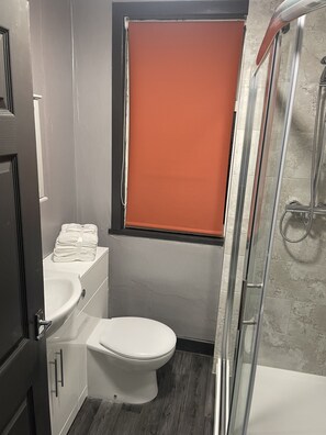 Een haardroger, handdoeken, zeep, toiletpapier