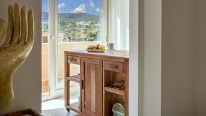 Ein Holztisch mit Blick auf eine gebirgige Landschaft durch ein großes Fenster.