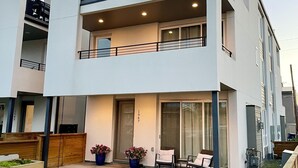 A modern two-story residential building with a balcony, a small garden area, and a wooden fence. - Rooftop + pool table + hot tub near Broncos Stadium! (Denver)
