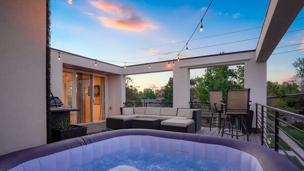 A hot tub on a balcony with outdoor seating and a view of the surrounding area. - Rooftop + pool table + hot tub near Broncos Stadium! (Denver)