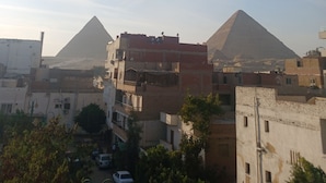 A view of a pyramid and surrounding buildings. - Pyramids home stay view (Giza)
