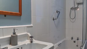 A bathroom with a sink, mirror, and shower. - 1 bedroom accommodation in Ilfracombe (Ilfracombe)