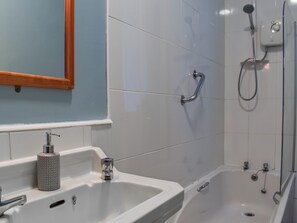 Ein Badezimmer mit Waschbecken, Spiegel und Dusche.