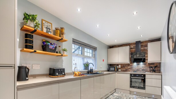 A modern kitchen with a large island, built-in appliances, and decorative shelves. - Totally refurbished cottage, decorated and equipped to a high standard. (Cornsay Colliery, Lanchester, Durham)