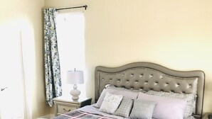 A bedroom with a tufted headboard, a plaid bedspread, and a ceiling fan. - Cozy Stay near UCHealth and Anschutz Hospitals  (Aurora)