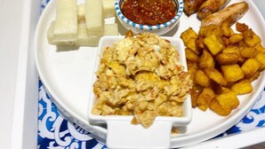 A tray with various food items including fried chicken, potato wedges, and a small bowl of sauce. - Viola Apartments & Suites (Abuja)