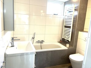 Een douche, handdoeken, zeep, toiletpapier