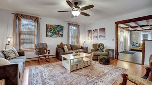 A spacious living room with a large ceiling fan, a coffee table, and two sofas.