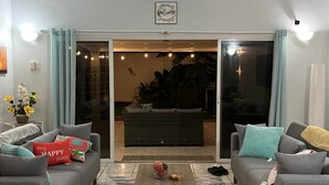 Un salon avec deux canapés gris, une table basse et un tapis à motifs.