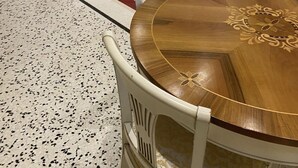 A dining area with a round wooden table and white chairs, a kitchen with white cabinets, and a door leading outside. - 2 bedroom apartment in venice (Venezia)