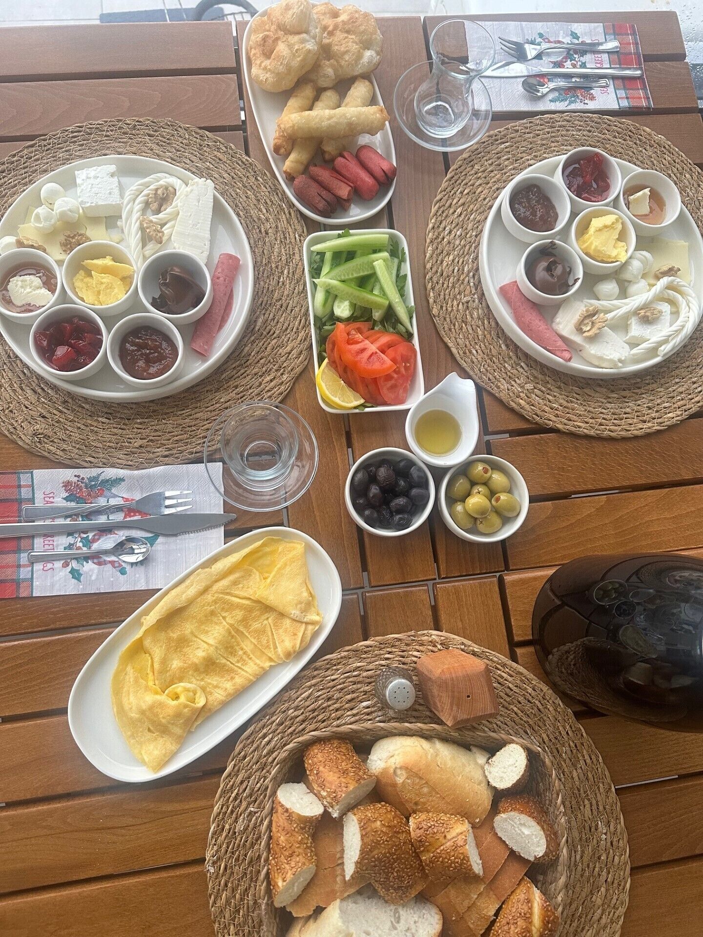 A table set with various food items including bread, hot dogs, and fruits, suggesting a casual dining experience.