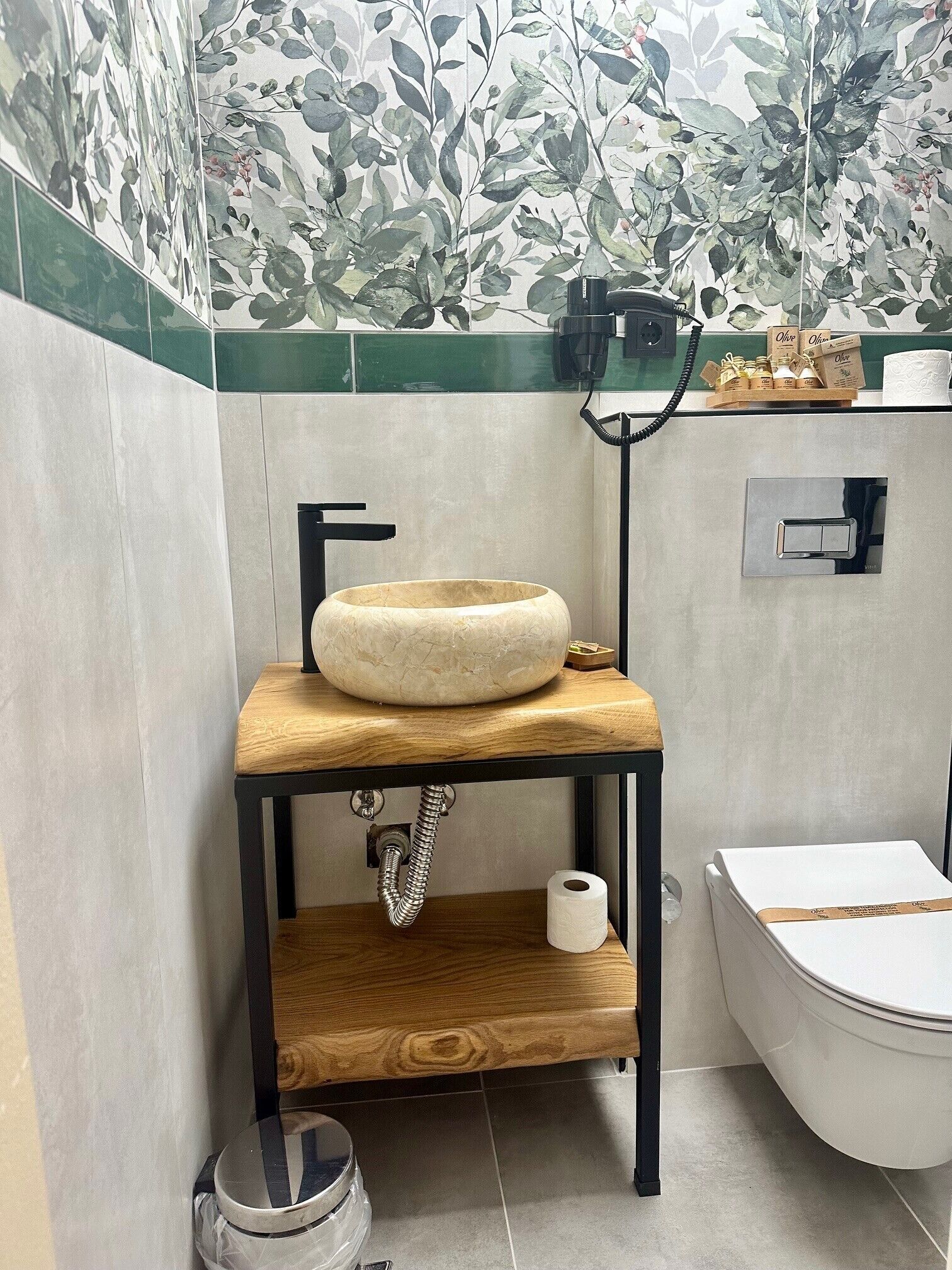 A bathroom with a wooden vanity, a round sink, and a toilet.