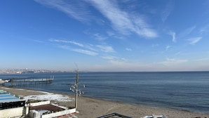 A coastal view with a clear sky, a sandy beach, and a pier extending into the water. - Kingway Suite (Tekirdag)