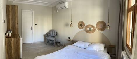 Un dormitorio con una cama grande, una silla, un armario y decoración en la pared.