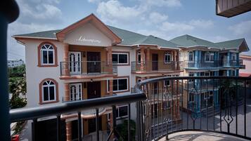 A multi-story building with balconies and a sign reading "Aheampong".