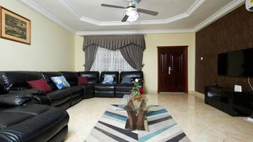 Deluxe appartement | Woonruimte | Een 70-inch smart-tv met kabelzenders