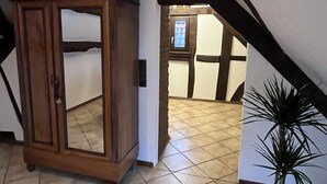 A room with a wooden cabinet, a potted plant, and a sloped ceiling. - Fachwerkhaus zum Hirsch in Mömbris (Mömbris)