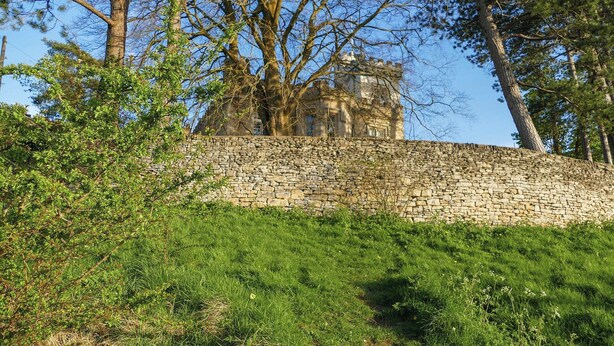 A stone wall with a building in the background. - A cosy one-bedroom first floor apartment on Rodborough Common. (Rodborough Common, near Stroud)
