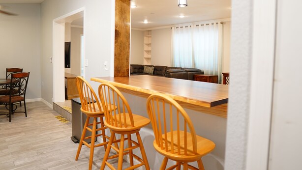 A modern kitchen with a wooden countertop and bar stools. - Spacious Home with Luxury Finish (Brandon)