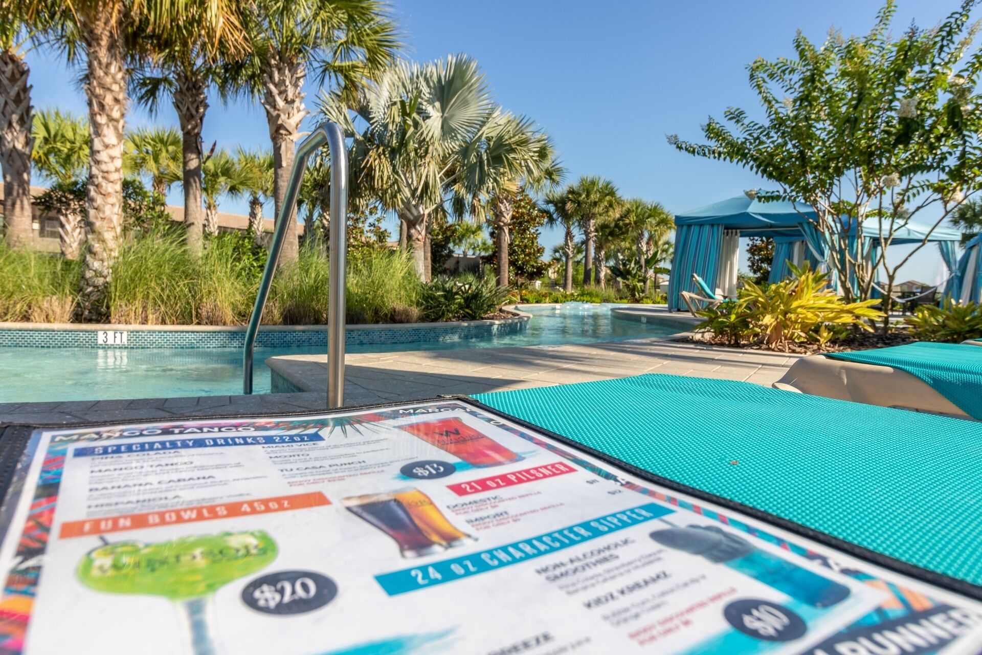 A poolside area with a menu board displaying drink specials.