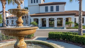 A fountain in front of a building with a tiled roof and arched windows. - Disney Emerald in Windsor Westside-Stunning 5 bed villa close to all attractions (Four Corners)