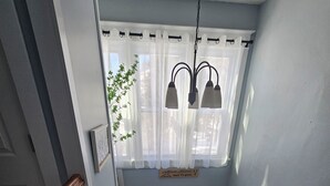 Una escalera de madera con barandillas blancas que conduce a una habitación con ventana y planta.