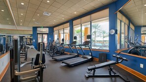 Et fitnesscenter med løbebånd, træningsmaskiner og et stort spejl.
