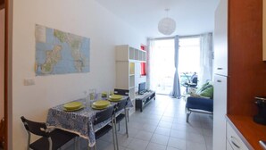 A dining area with a map on the wall, a dining table with chairs, a sofa, and a TV. - Cozy apartment in Isca Marina with WiFi (Isca Marina)