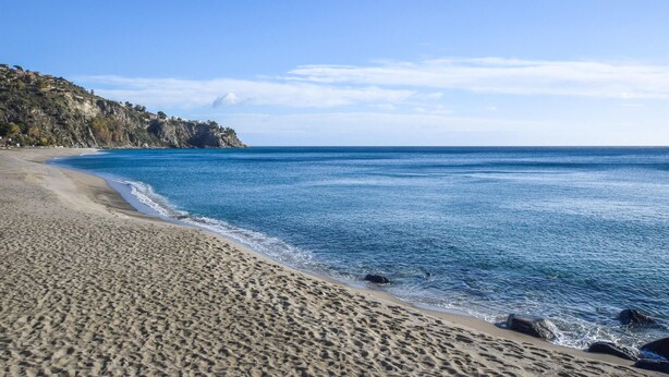 A sandy beach with clear blue water and rocky outcrops. - Cozy apartment in Isca Marina with WiFi (Isca Marina)