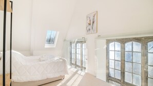 Ein Schlafzimmer mit einem Bett, einem Fenster und einem Gemälde.