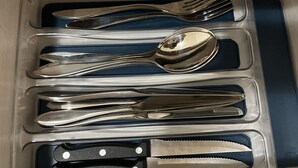 Eine Schublade mit ordentlich angeordnetem Besteck, darunter Gabeln, Messer und Löffel.