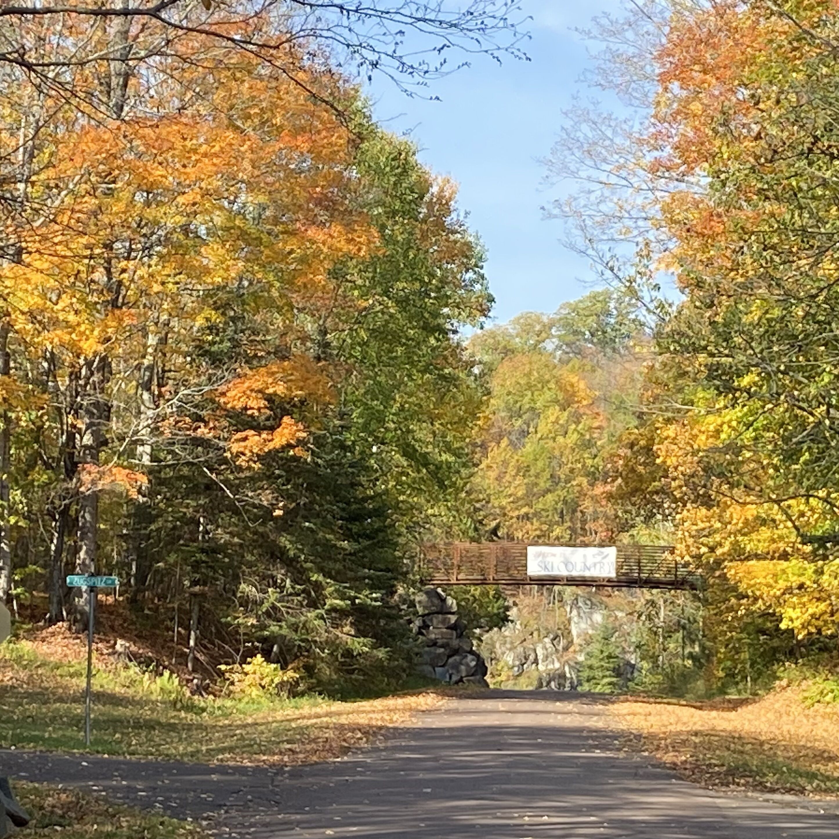 A road leading to a bridge with a sign that reads "SKILCOUNTRY".