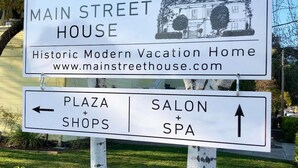 Skilt for The Main Street House, et historisk, moderne feriehus, med vejvisning til butikker på pladsen samt salon og spa.