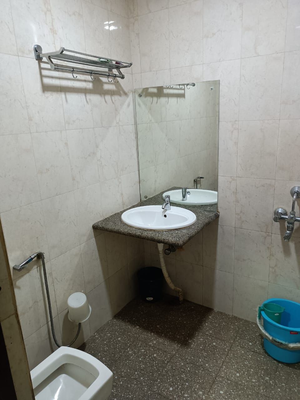 A small bathroom with a white sink, a mirror, a toilet, and a shower.