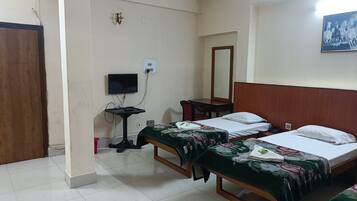 A hotel room with two single beds, a desk with a chair, a television, and a mirror on the wall.