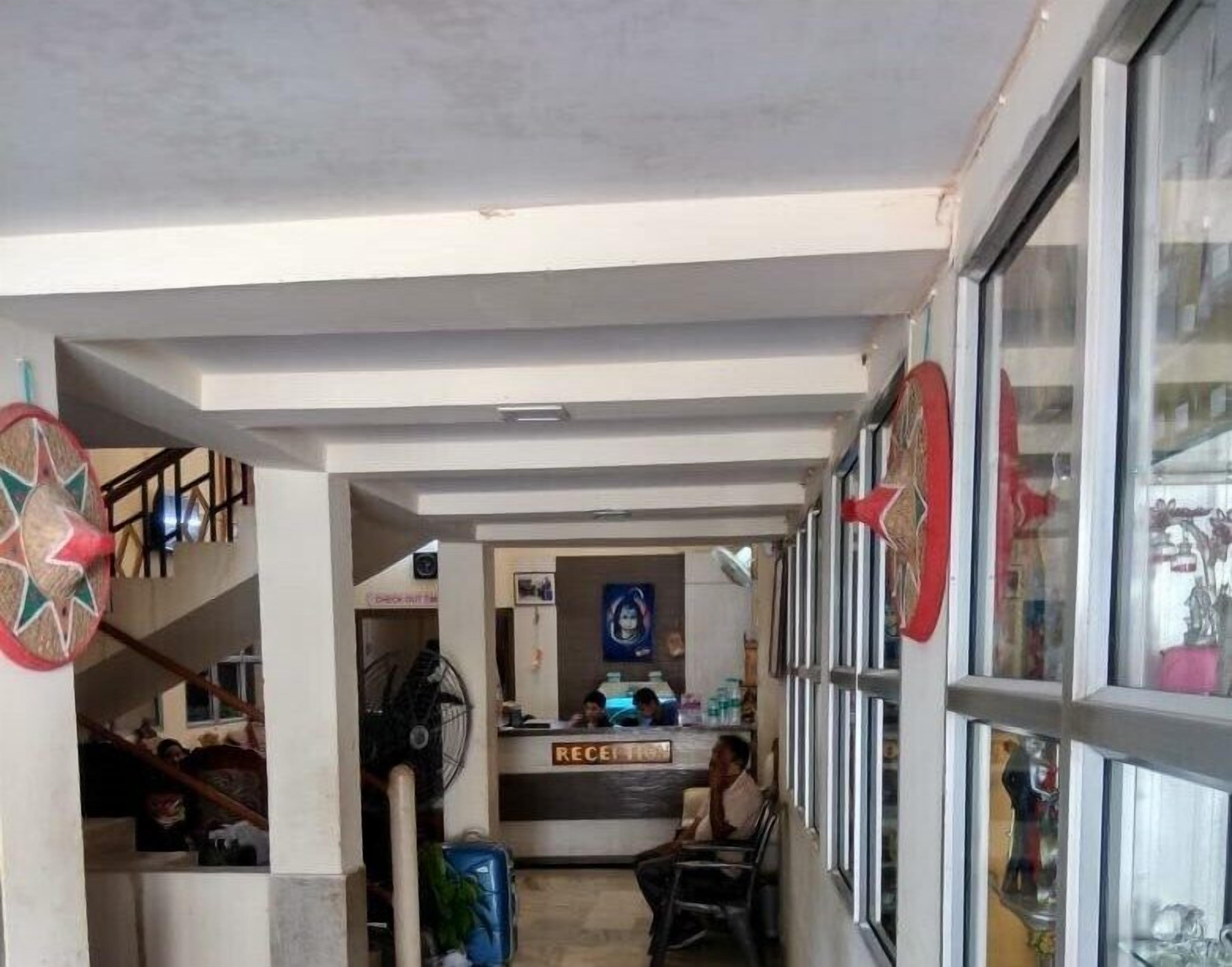 A reception area with a counter, a fan, and a sign labeled 'RECEPTION'.