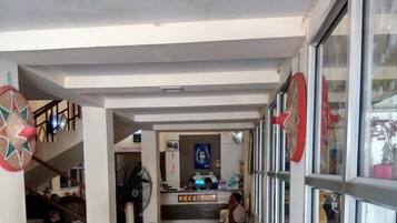 A reception area with a counter, a fan, and a sign labeled 'RECEPTION'.