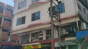 A multi-story building with several shops on the ground floor, including a visible restaurant named "Kusum Hotel & Restaraunt". - Kusum Hotel And Restaurant (Dibrugarh)